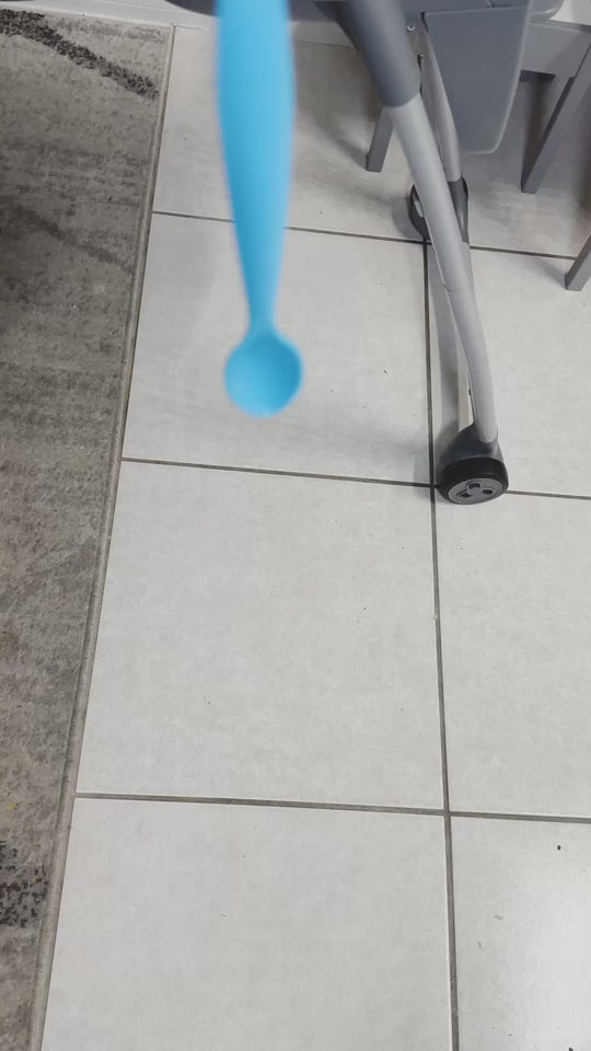 A blue Dropless plate with a black african american toddler kid dropping her spoon 